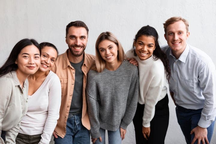 A team of six colleagues standing together and smiling.